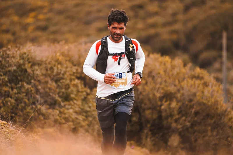 A trail runner smiling in golden evening light.