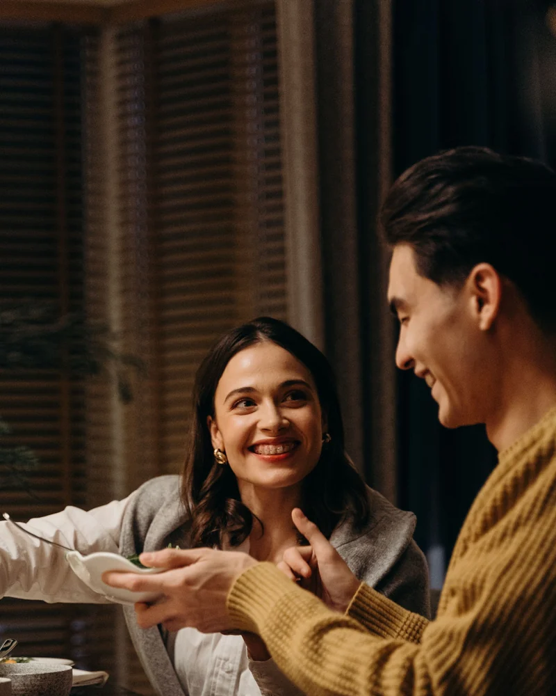 A couple laughing over dinner.