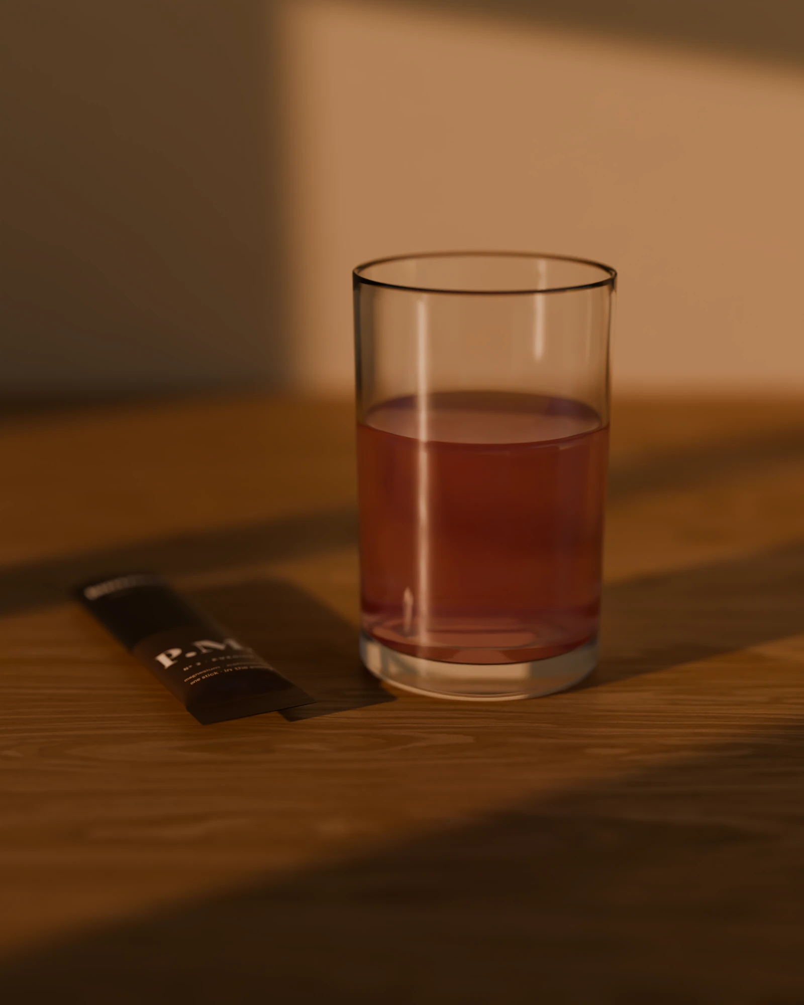 A small glass of P.M. in warm evening light, the opened stick beside it.